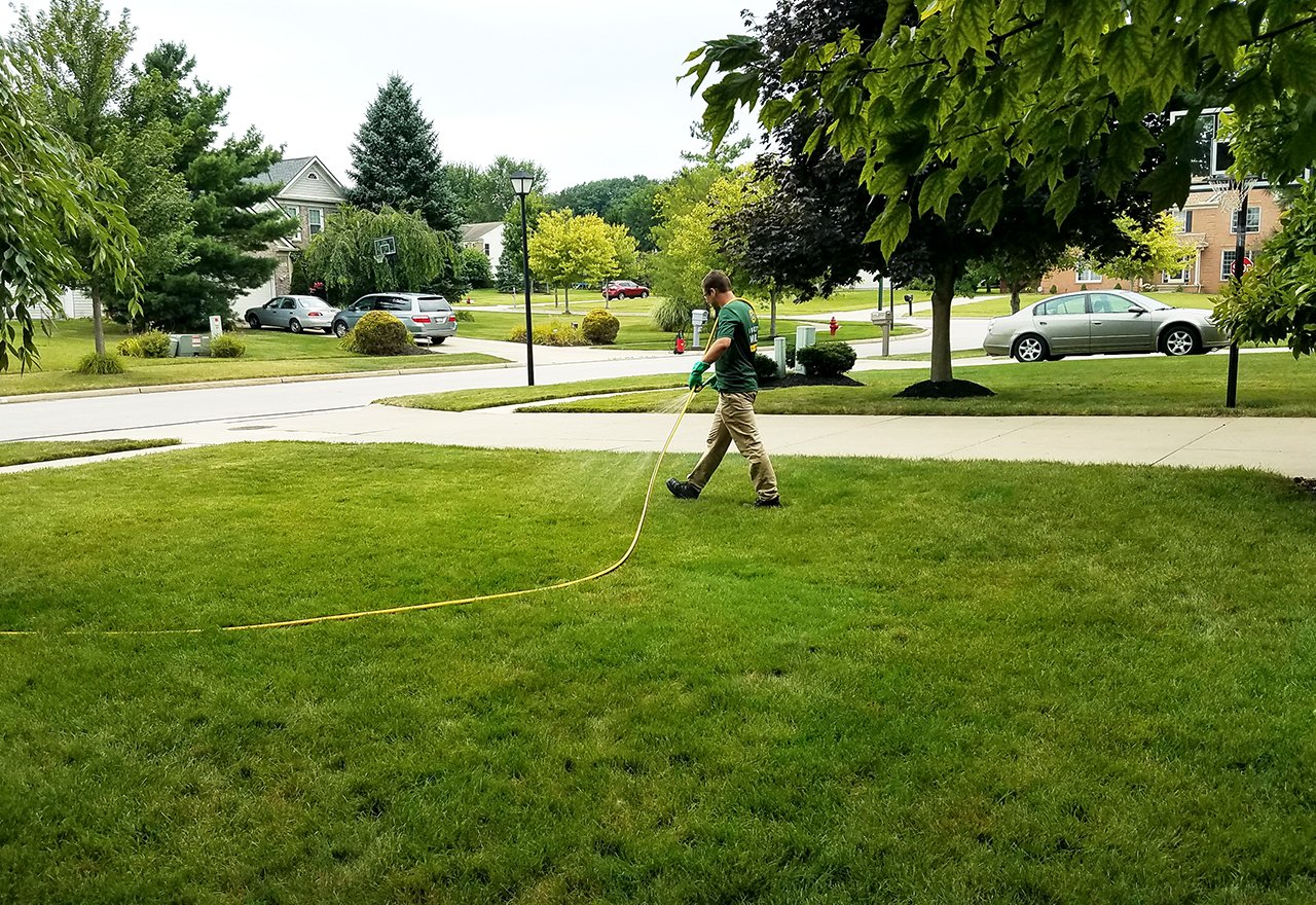 Technician Spraying Residential House