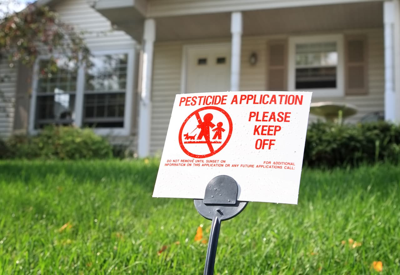 Small warning sign placed on a lawn after chemical treatment
